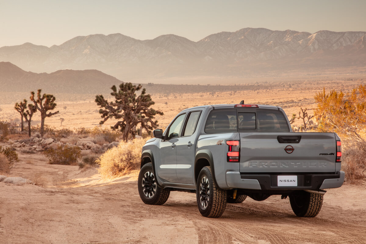 Vue 3/4 arrière du Nissan Frontier 2022 garé dans un désert face à une chaîne de montagnes au loin