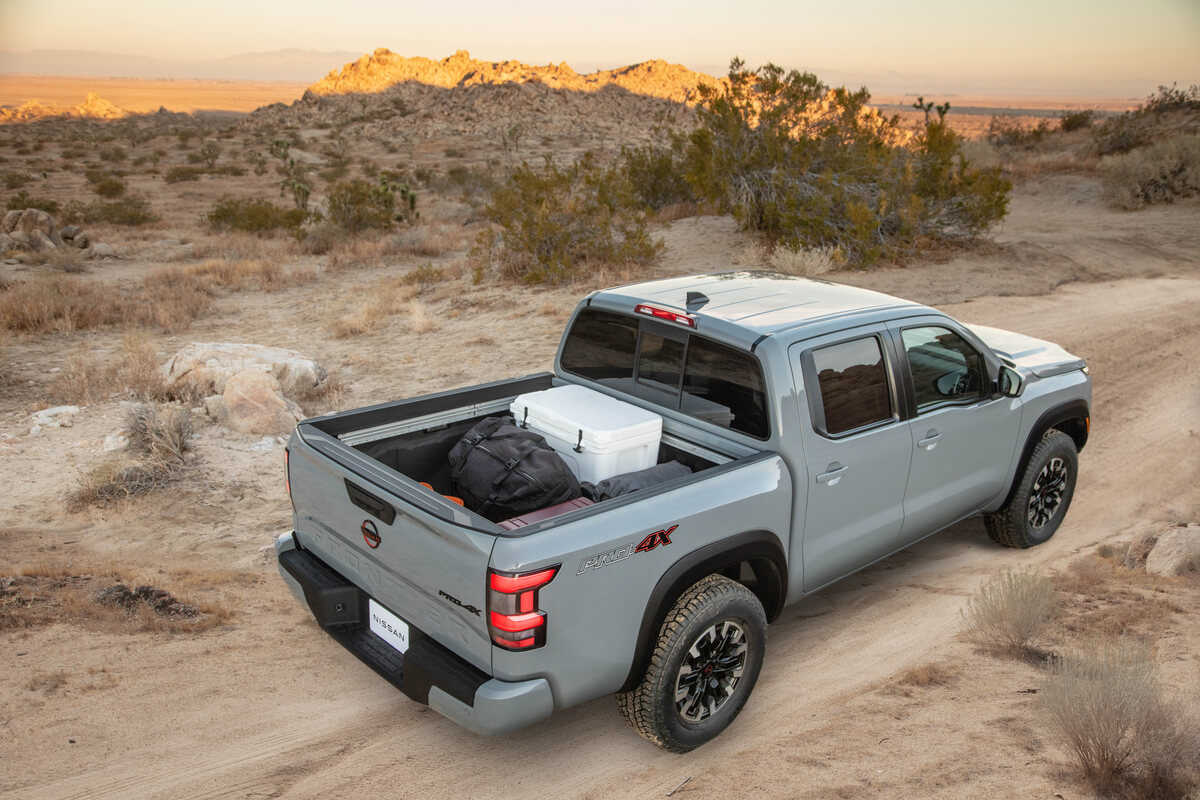 Vue 3/4 de la caisse du Nissan Frontier PRO-4X 2022 roulant sur une piste dans un désert