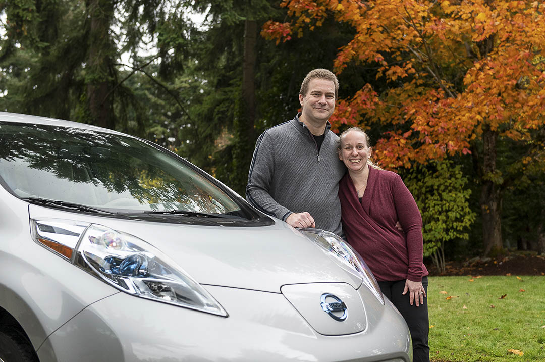 Un couple heureux accoté sur la Nissan Leaf 2022