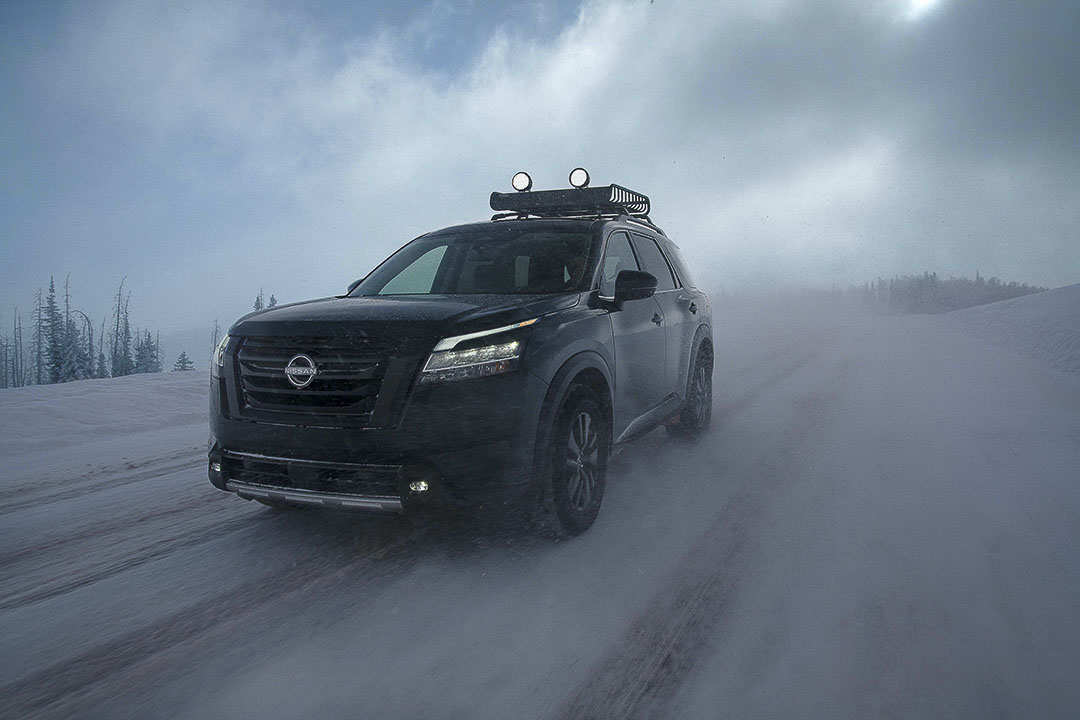 Vue 3/4 avant du Nissan Pathfinder 2022 avec ses antibrouillards à SEL roulant dans une tempête de neige 