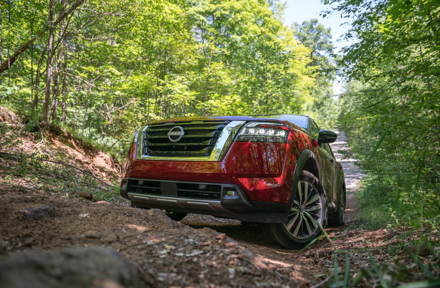 Le Nissan Pathfinder 2022 garé sur une piste en forêt