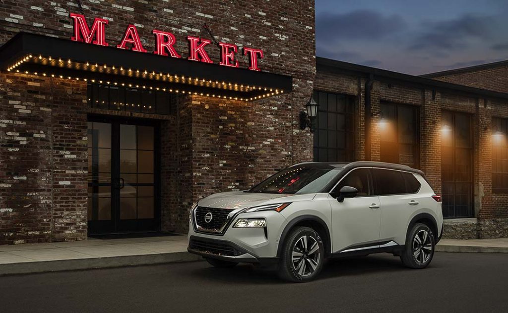 Nissan Rogue 2021 blanc stationné au bord d'un magasin à l'extérieur