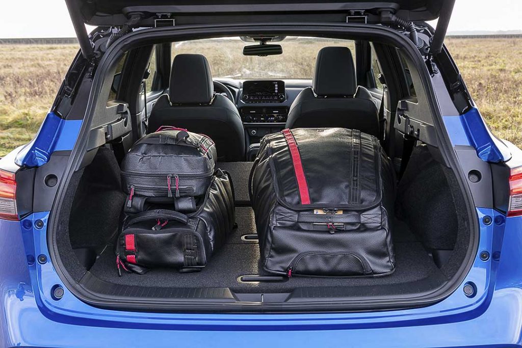 La banquette arrière rabattue du coffre du Nissan Qashqai 2021 contenant trois valises
