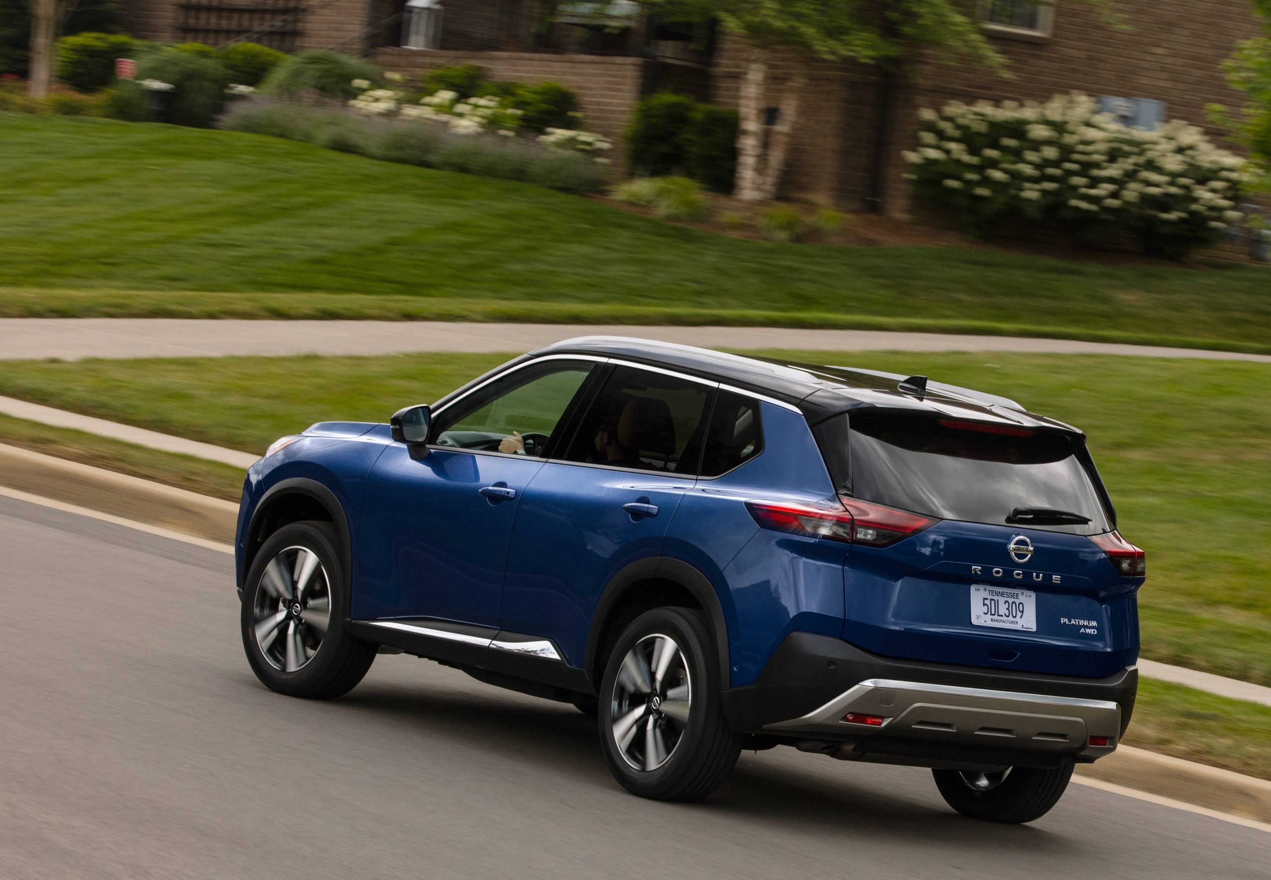 vue arrière du Nissan Rogue 2021 bleu conduisant dans la rue